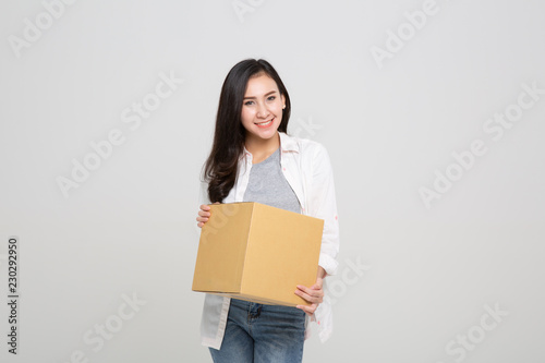 Delivery, relocation and unpacking. Smiling young woman holding cardboard box isolated © uinmine