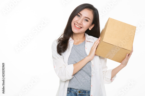 Delivery, relocation and unpacking. Smiling young woman holding cardboard box isolated on white background © uinmine