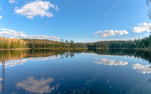 The lake Glubelka in the forest. Belarus. Autumn. The reflection of the clouds in the water