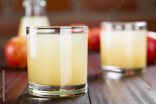 фотографія Refreshing apple juice in glasses with apples and bottle in the back, photograph