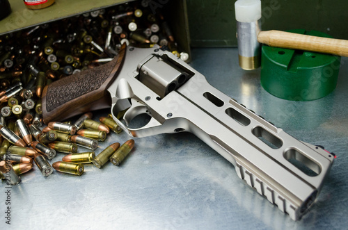 Large bore magnum revolver with gunsmith tools and ammunition in background