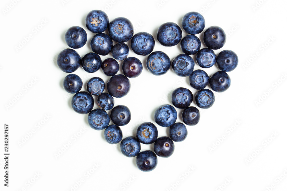 Blueberries in the shape of heart on an isolated white watercolor background with a single raspberry in the center. The concept of St. Valentine's Day. Blueberries in the shape of heart on an isolated white watercolor background with a single raspberry in the center. The concept of St. Valentine's Day.