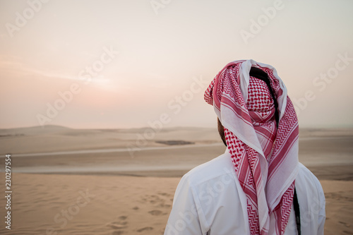 Arab man in the desert is meeting sunrise photo