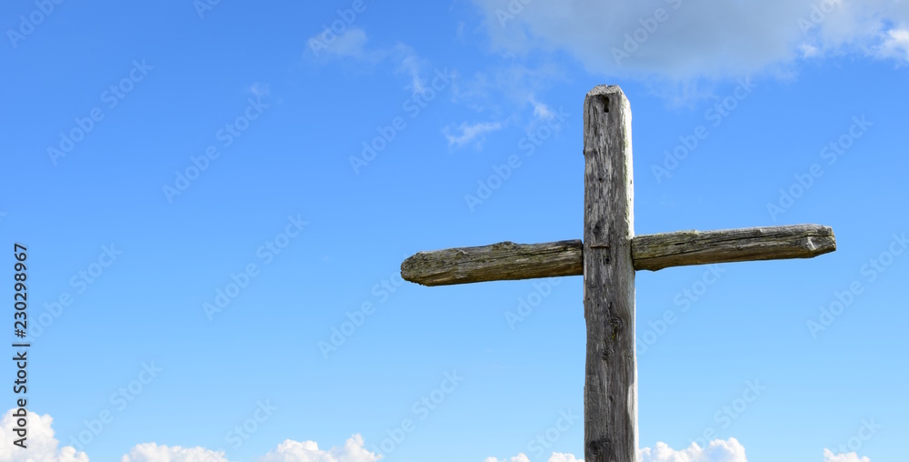 Holzkreuz vor blauen Himmel mit weißen Wolken, freigestellt, Banner
