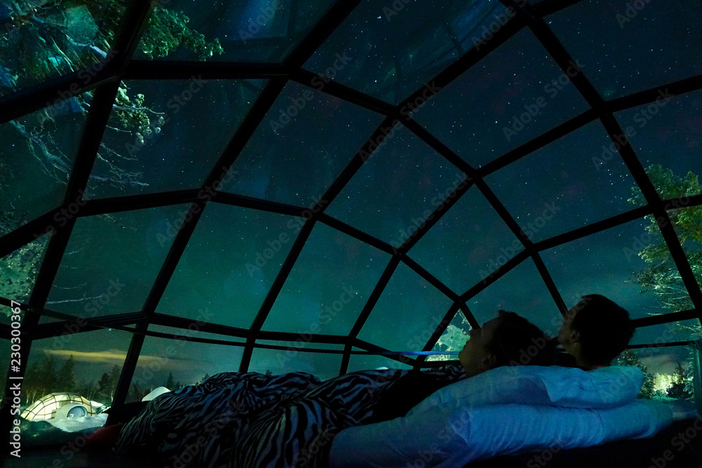 Φωτογραφία CLOSE UP Young Caucasian tourist couple observing the night sky from glass house
