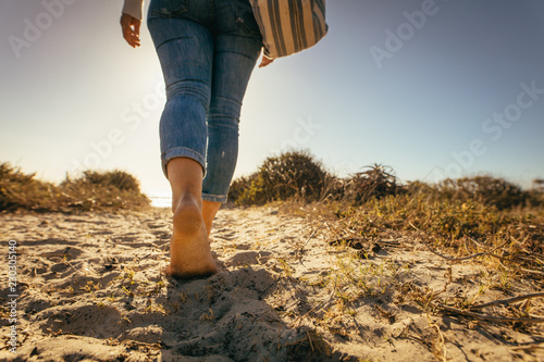 Close up of legs of a woman walking on beach