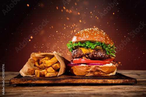 Tasty burger with french fries and fire.