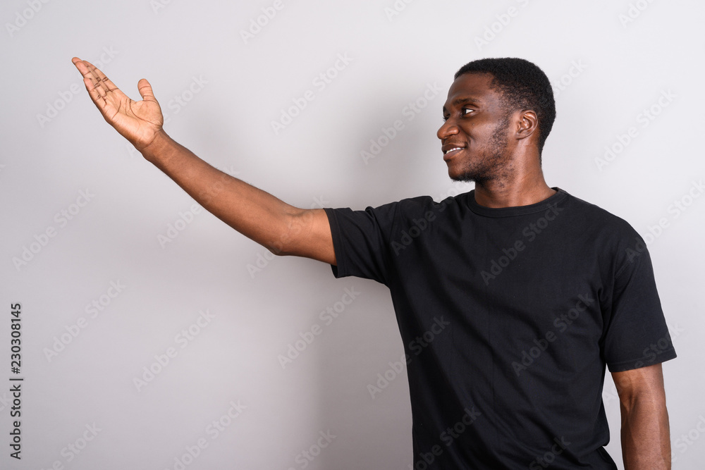Young African man wearing black shirt against gray background Young African man wearing black shirt against gray background