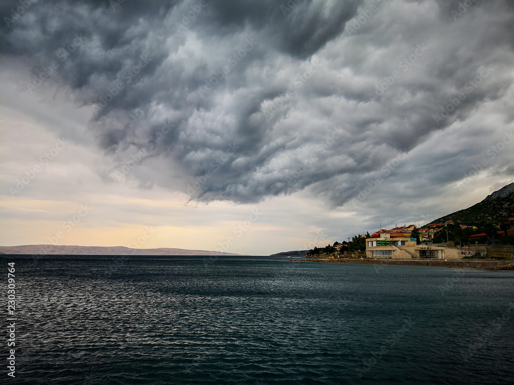 Stormy clouds of bora wind at small resort on the Adriatic coast in Croatia, located underneath Velebit overlooking the island of Pag.