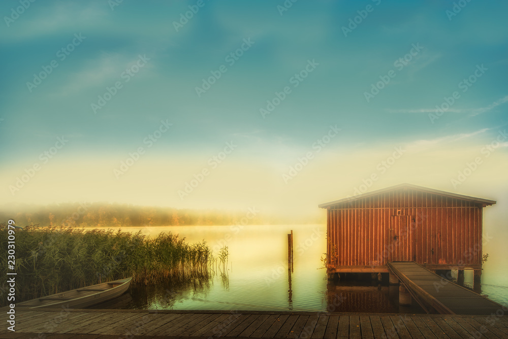 Fantastic Lichsstimmung on a lake with a boat and a boat shed. Concept: vacation and travel Fantastic Lichsstimmung on a lake with a boat and a boat shed. Concept: vacation and travel