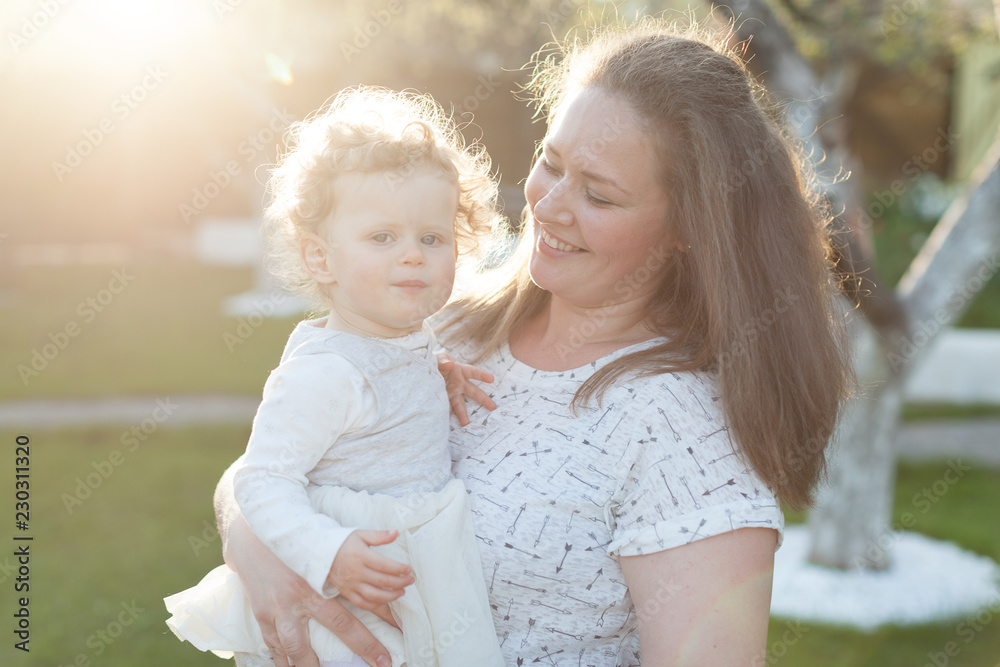 Obraz premium Mother with her little curly daughter playing on the background