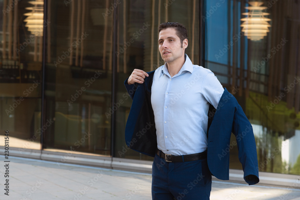 Tired businessman wearing his jacket in a hurry to go home after work