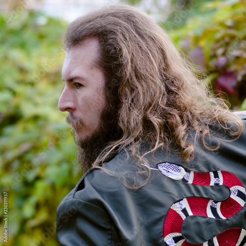 Portrait of man with beard posing outdoors at sunny evening