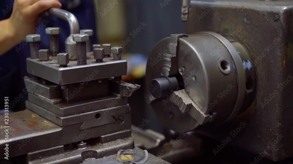 worker is changing detail in turning machine in factory workshop, using key, close-up of hands worker is changing detail in turning machine in factory workshop, using key, close-up of hands
