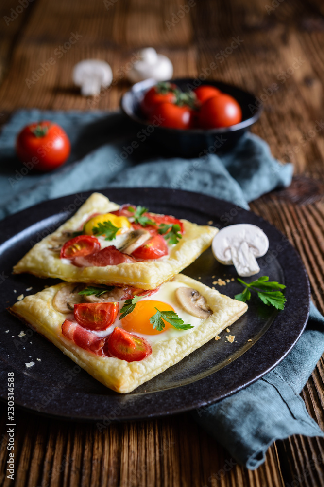 Puff pastry pies with egg, bacon, mushrooms and tomato Puff pastry pies with egg, bacon, mushrooms and tomato