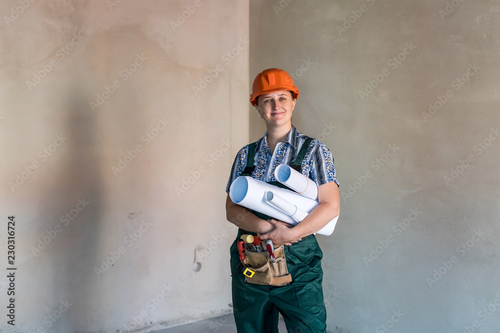 Woman in working uniform with tool belt and blueprints Woman in working uniform with tool belt and blueprints