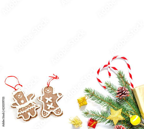 Branch of a Christmas tree with balls  fir cones  traditional candies and boxes with gifts isolated on a white background. Christmas and New Year background with free space for text.