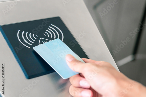 Hand holding Blue Card to access Electronic Entrance Scanner photo