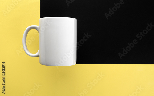 White mug on yellow and black background