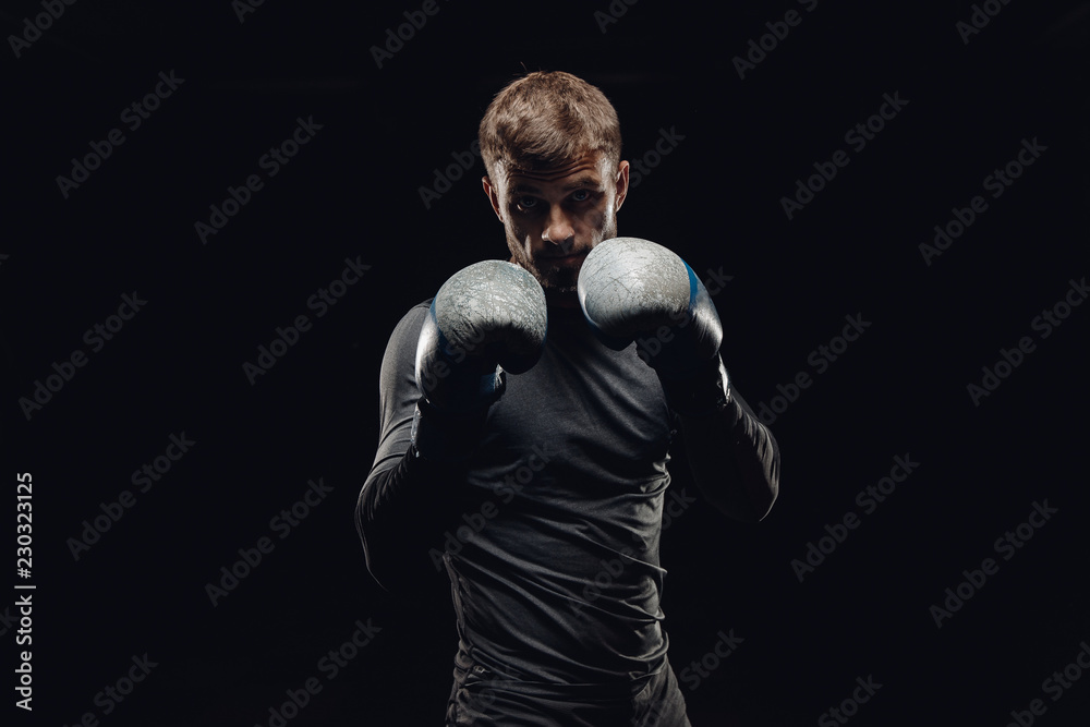 Portrait of boxer man in gloves against dark background. Concept training boxing.