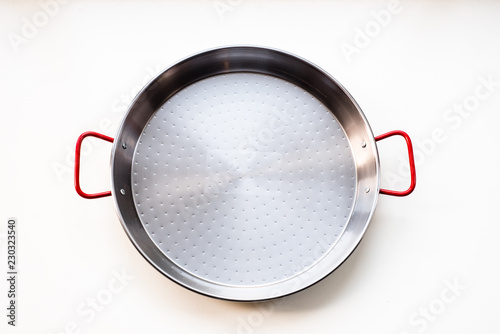 New unseasoned carbon steel paella pan isolated on white background, flat lay