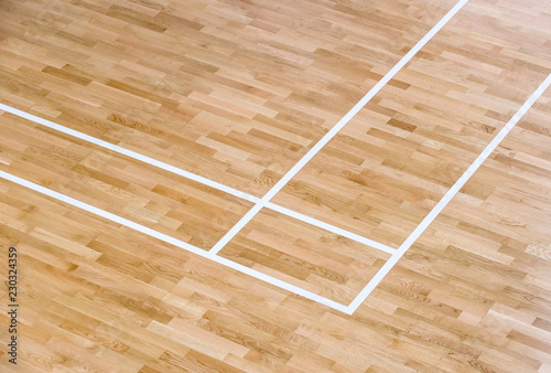 wooden floor volleyball, basketball, badminton court with light effect Wooden floor of sports hall with marking lines line on wooden floor indoor, gym court © Augustas Cetkauskas