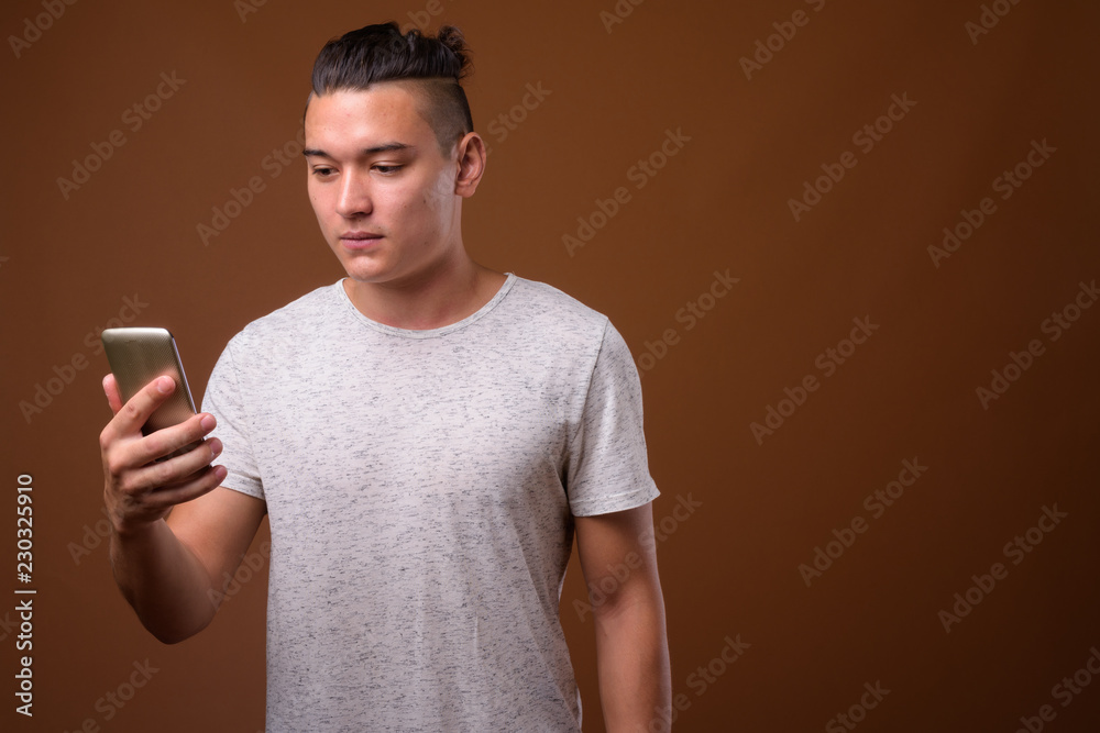 Young handsome multi-ethnic man against brown background Young handsome multi-ethnic man against brown background