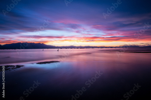 Beautiful sunset on Lake Tahoe with bright purple  pinks and oranges in the sky. Long exposure  calm water