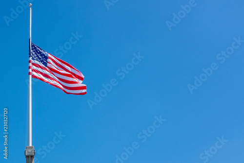Flag of the United States of America at half staff on a clear windy day. photo
