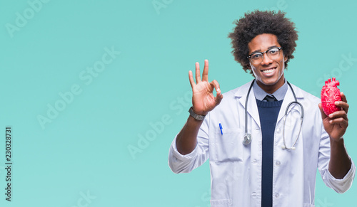 Afro american cardiologist doctor man over isolated background doing ok sign with fingers, excellent symbol