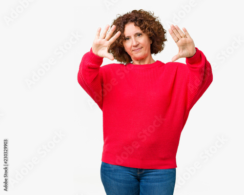 Beautiful middle ager senior woman red winter sweater over isolated background Smiling doing frame using hands palms and fingers, camera perspective