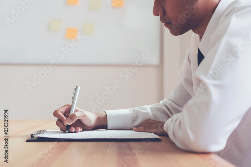 Businessman writing form submit resume employer to review job application. Concept presents ability for the company to agree with position of job. photo