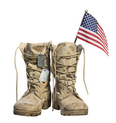 Old military combat boots with the American flag and dog tags, isolated on white background. Memorial Day or Veterans day concept.