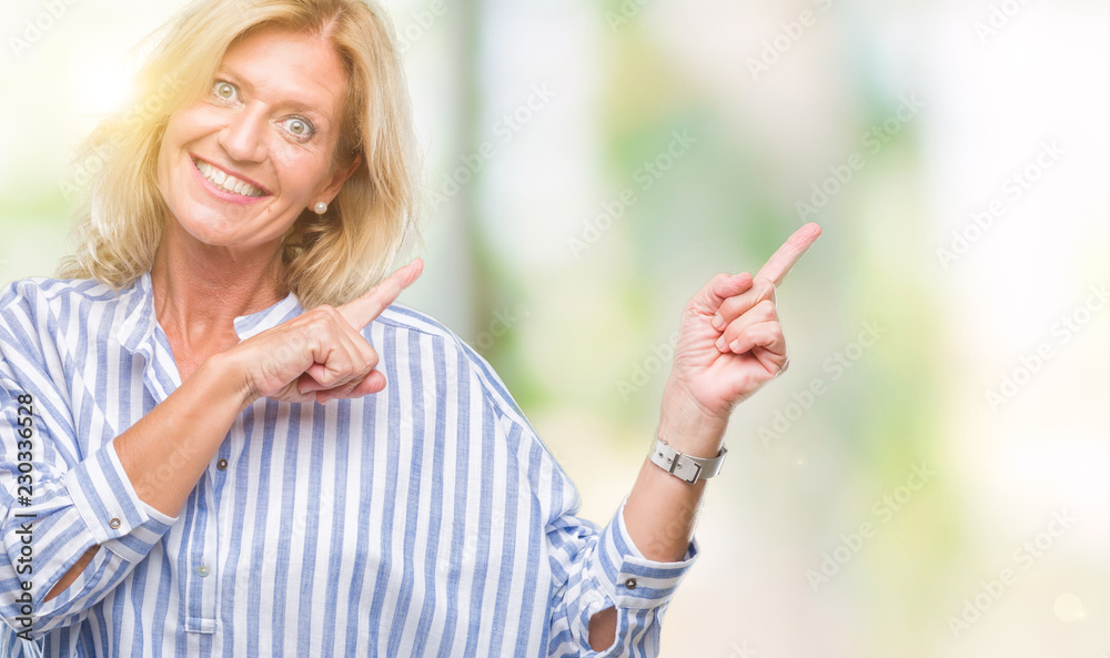 Middle age blonde business woman over isolated background smiling and looking at the camera pointing with two hands and fingers to the side. Middle age blonde business woman over isolated background smiling and looking at the camera pointing with two hands and fingers to the side.