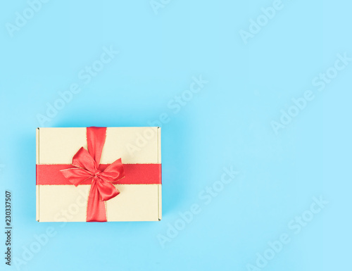 Fototapeta Naklejka Na Ścianę i Meble -  Gift box with red ribbon on color background. Object for Christmas day or Birthday present.