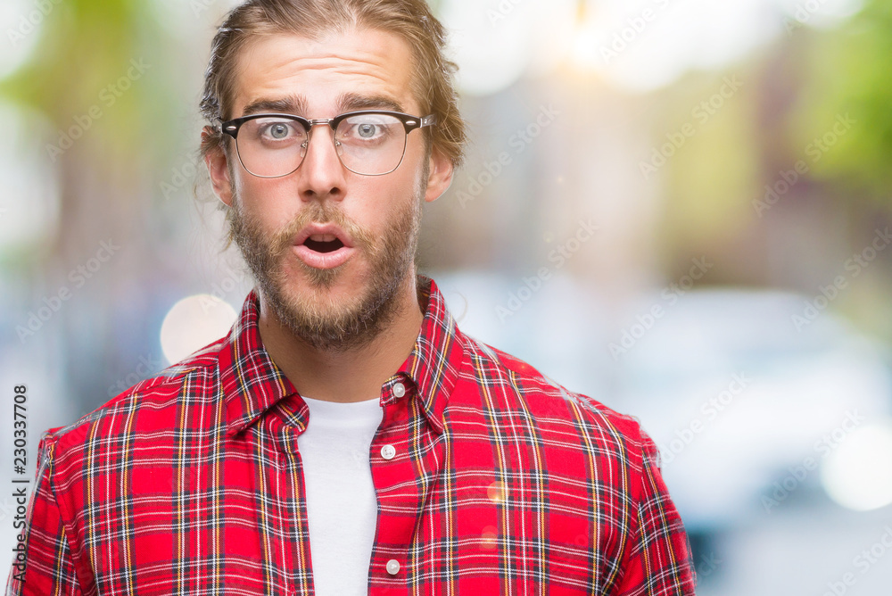 Young handsome man with long hair wearing glasses over isolated background afraid and shocked with surprise expression, fear and excited face. Young handsome man with long hair wearing glasses over isolated background afraid and shocked with surprise expression, fear and excited face.