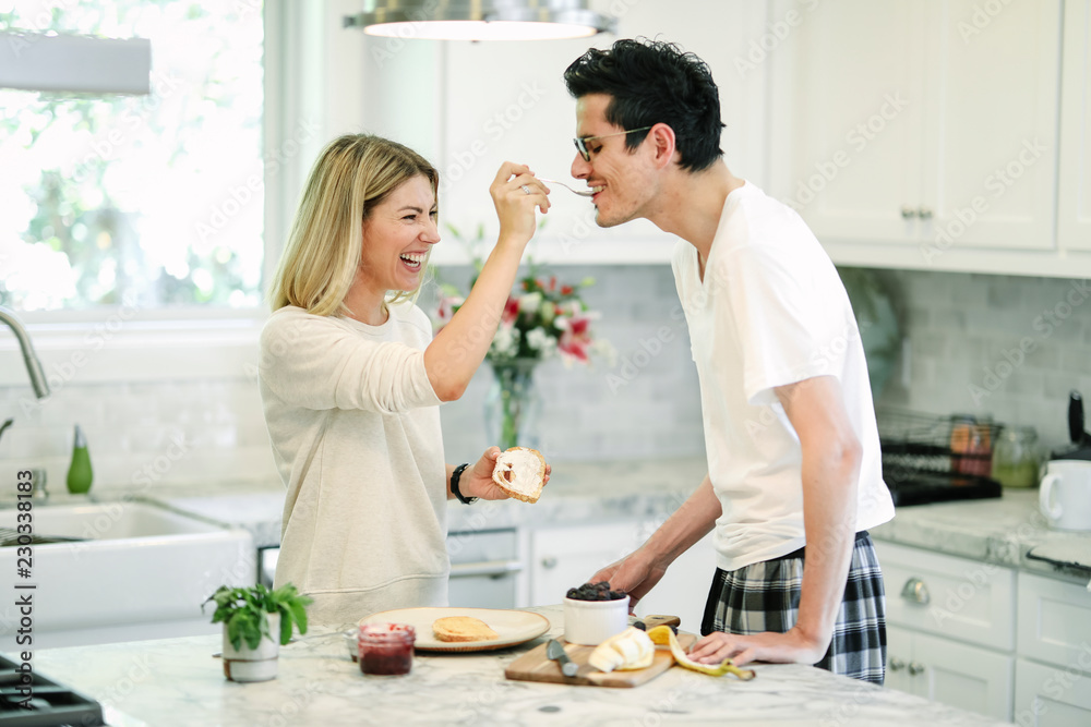 Woman feeding blackberry jam to her boyfriend Woman feeding blackberry jam to her boyfriend