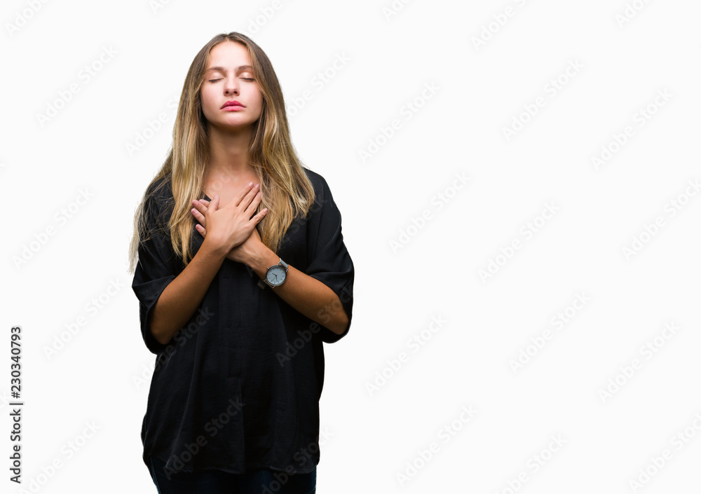 Young beautiful blonde woman over isolated background smiling with hands on chest with closed eyes and grateful gesture on face. Health concept. Young beautiful blonde woman over isolated background smiling with hands on chest with closed eyes and grateful gesture on face. Health concept.