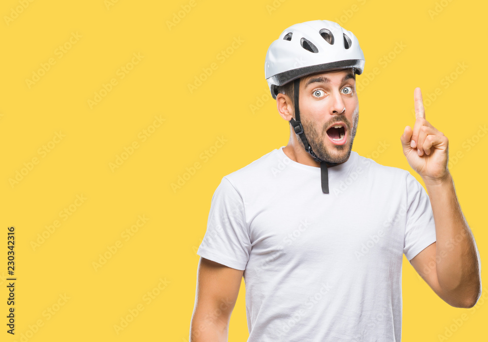 Young handsome man wearing cyclist safety helmet over isolated background pointing finger up with successful idea. Exited and happy. Number one.