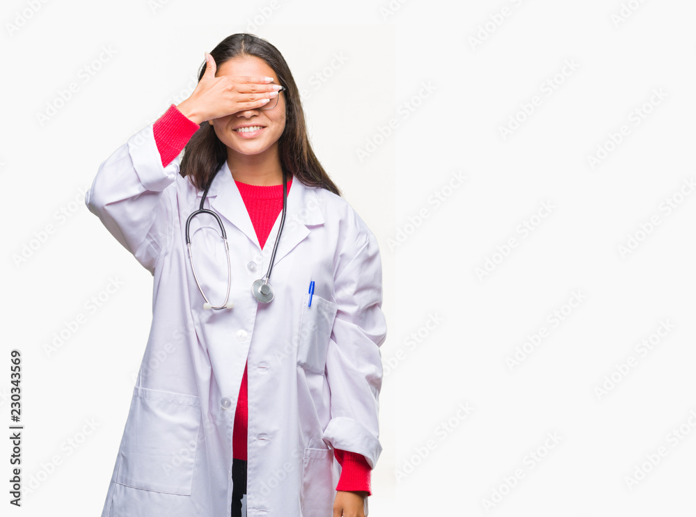 Young arab doctor woman over isolated background smiling and laughing with hand on face covering eyes for surprise. Blind concept. Young arab doctor woman over isolated background smiling and laughing with hand on face covering eyes for surprise. Blind concept.