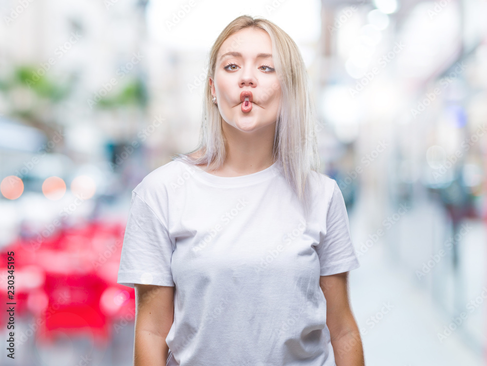 Young blonde woman over isolated background making fish face with lips, crazy and comical gesture. Funny expression. Young blonde woman over isolated background making fish face with lips, crazy and comical gesture. Funny expression.
