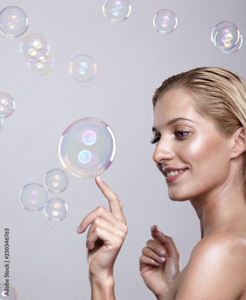 Beautiful young blonde woman touches the bubble with her finger Beautiful young blonde woman touches the bubble with her finger
