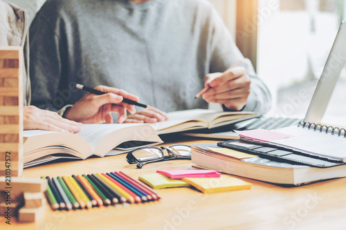 High school or college students studying and reading together in library