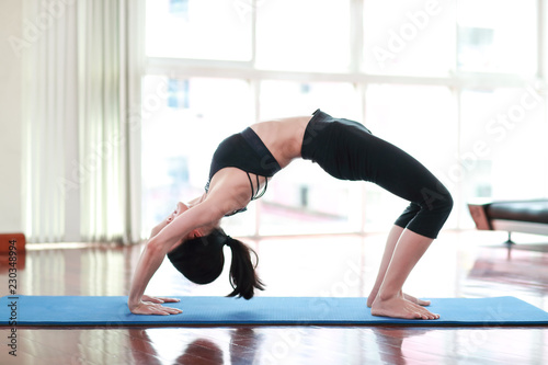 sporty girl practicing yoga and stretching in gym