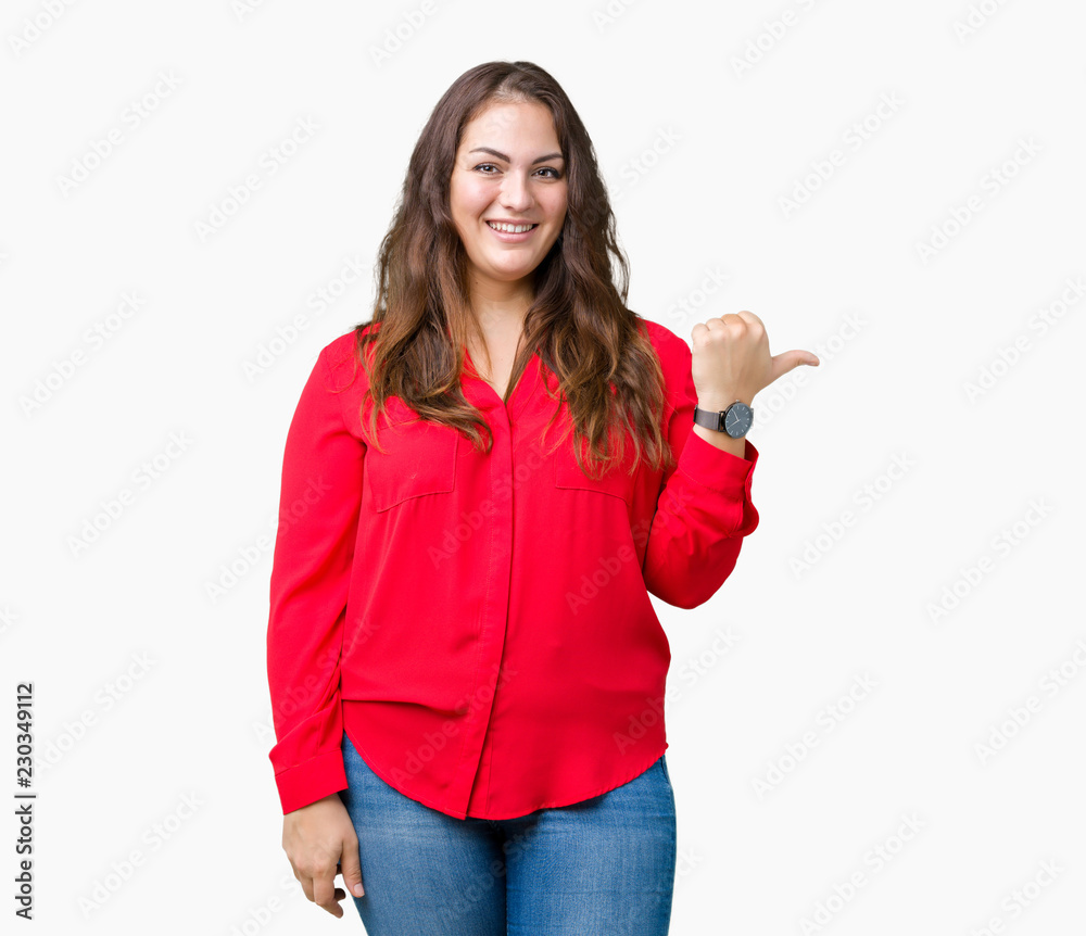 Beautiful plus size young business woman over isolated background smiling with happy face looking and pointing to the side with thumb up. Beautiful plus size young business woman over isolated background smiling with happy face looking and pointing to the side with thumb up.