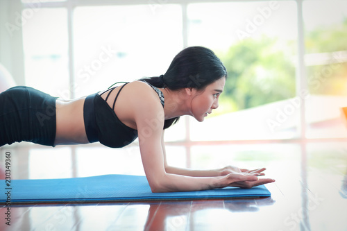 sporty girl practicing yoga and stretching in gym
