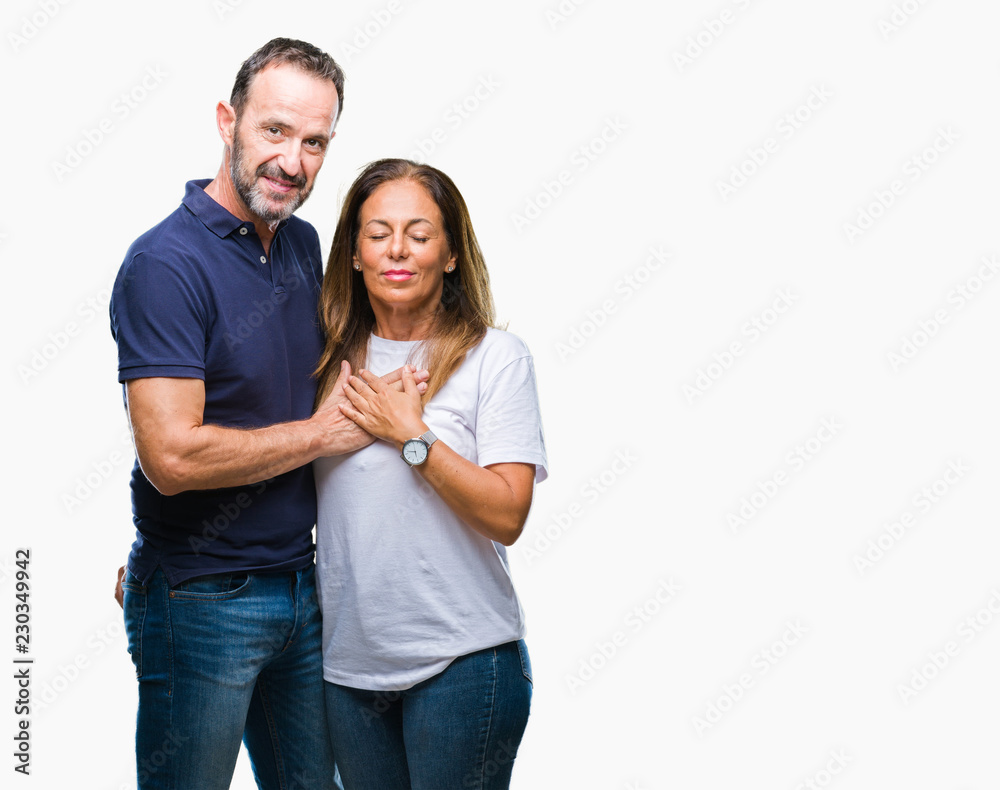 Middle age hispanic casual couple over isolated background smiling with hands on chest with closed eyes and grateful gesture on face. Health concept. Middle age hispanic casual couple over isolated background smiling with hands on chest with closed eyes and grateful gesture on face. Health concept.