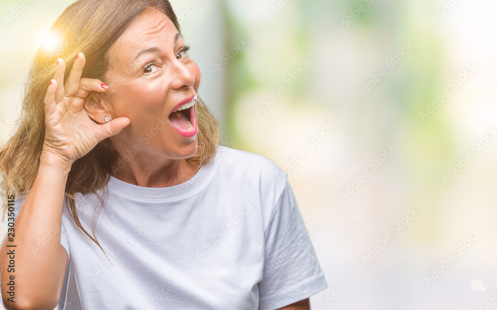 Middle age senior hispanic woman over isolated background smiling with hand over ear listening an hearing to rumor or gossip. Deafness concept. Middle age senior hispanic woman over isolated background smiling with hand over ear listening an hearing to rumor or gossip. Deafness concept.