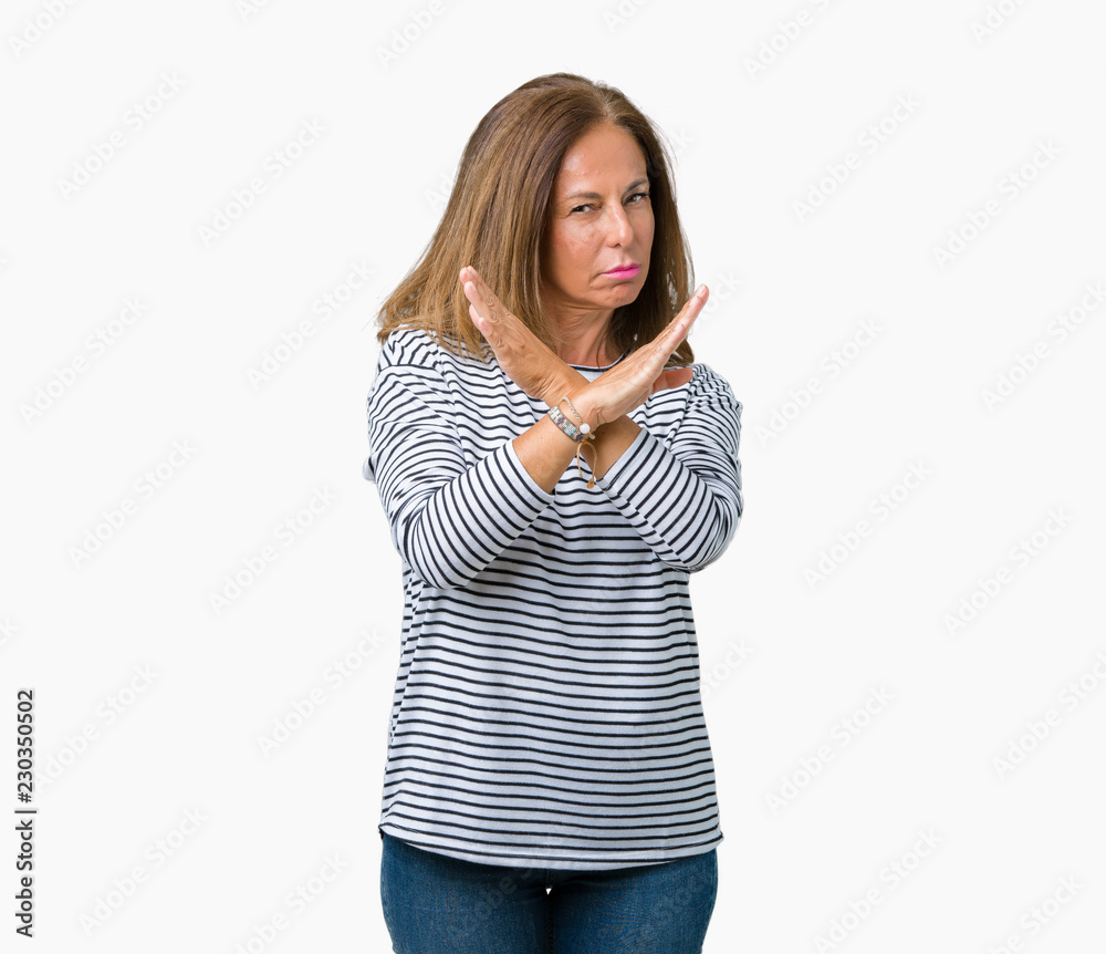 Beautiful middle age woman wearing stripes sweater over isolated background Rejection expression crossing arms doing negative sign, angry face Beautiful middle age woman wearing stripes sweater over isolated background Rejection expression crossing arms doing negative sign, angry face