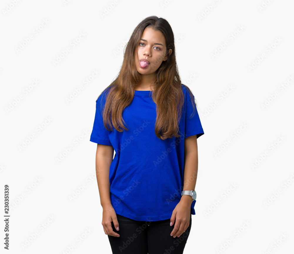 Young beautiful brunette woman wearing blue t-shirt over isolated background sticking tongue out happy with funny expression. Emotion concept. Young beautiful brunette woman wearing blue t-shirt over isolated background sticking tongue out happy with funny expression. Emotion concept.